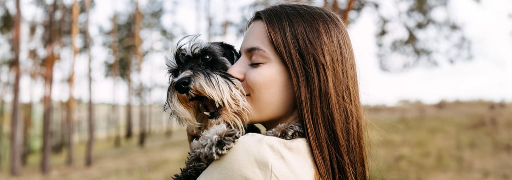 A woman hugging her miniature schnauzer.