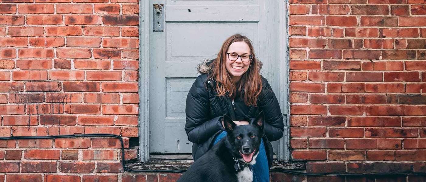 A woman sitting on a step with her dog
