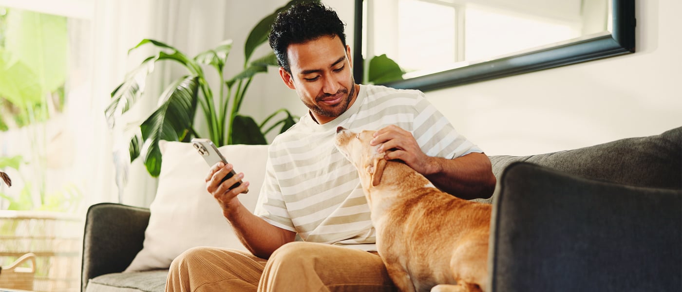 A man sitting on a sofa with his dog.