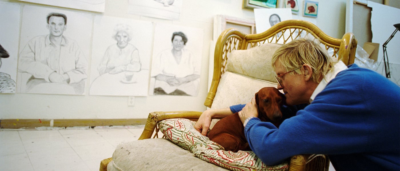 David Hockney kissing his dachshund. 
