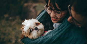 couple snuggling dog in jumper