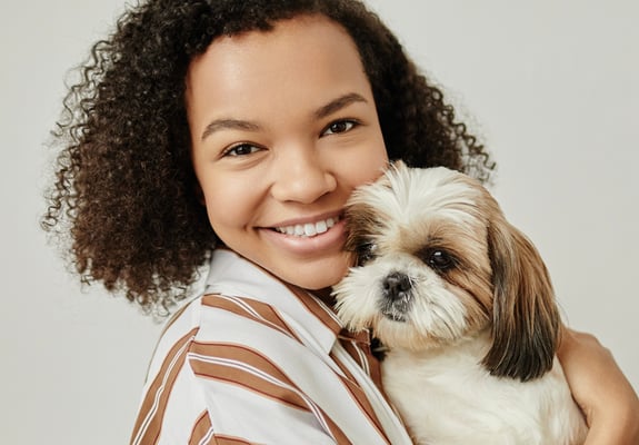 A woman cuddles her Shih Tzu