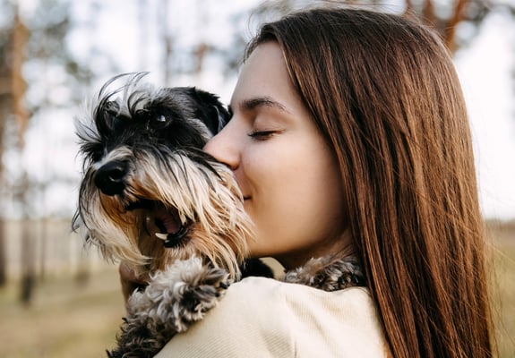 A woman hugging her miniature schnauzer.
