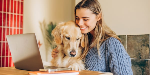 A woman smiling with her golden retriever.