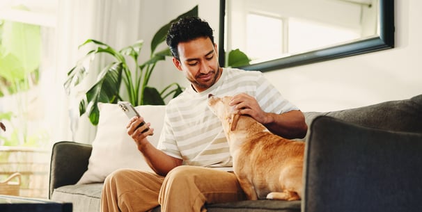 A man sitting on a sofa with his dog.