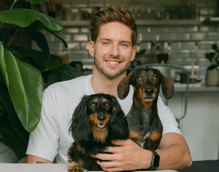 A man protected by pet insurance sat with his dachshund dogs. 