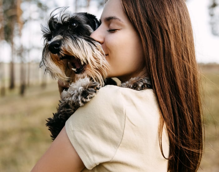 A woman hugging her miniature schnauzer.