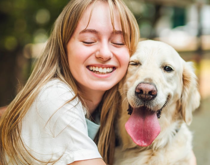 Owner smiling next to Golden Retriever dog with it's tongue out