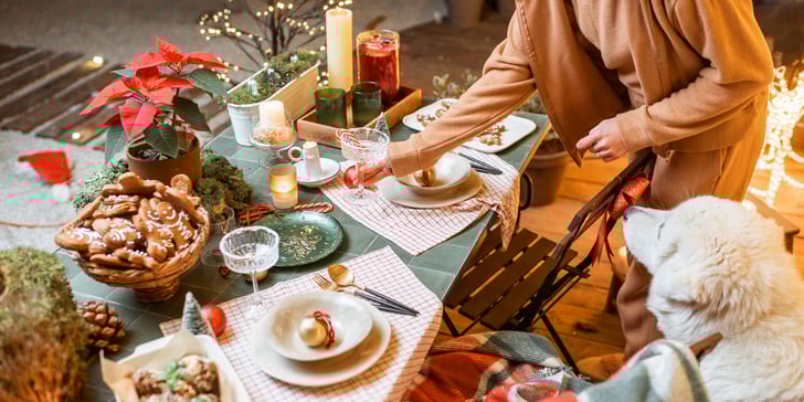 A christmas spread with a dog in the corner.