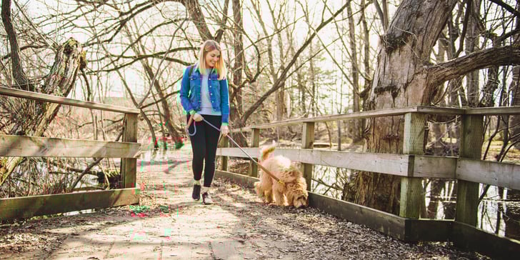 A woman walking her Labradoodle.