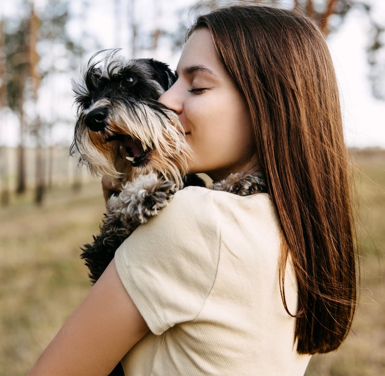 A woman hugging her miniature schnauzer.