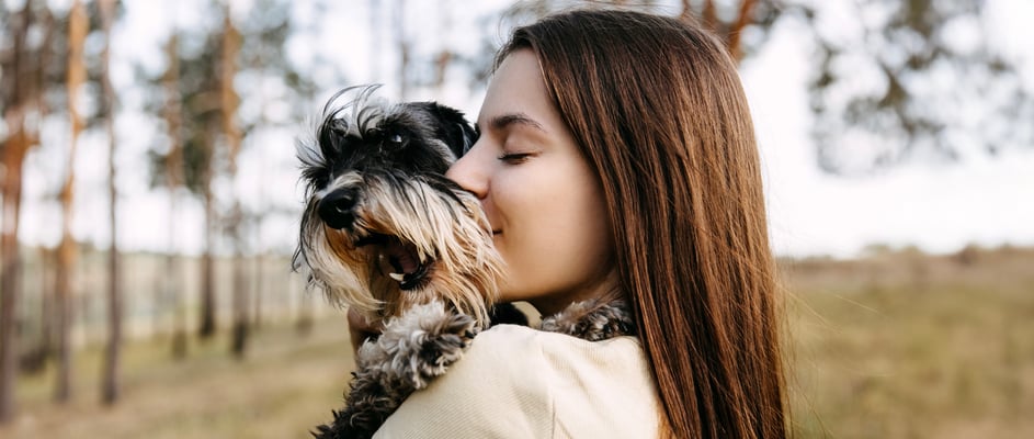 A woman hugging her miniature schnauzer.