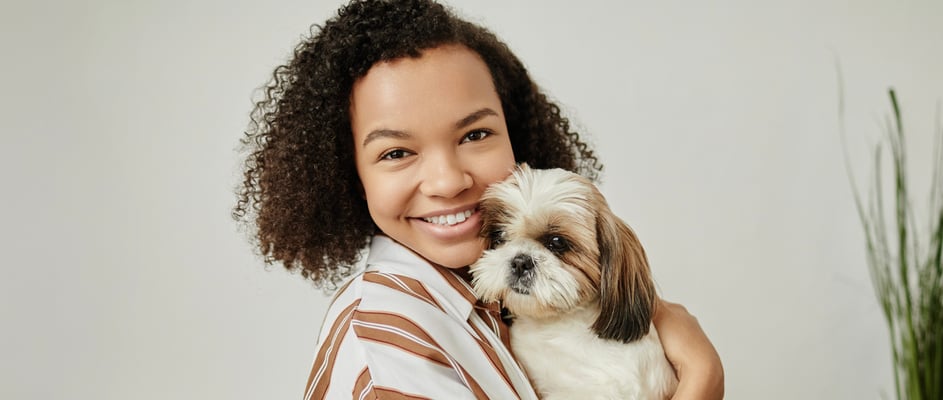 A woman cuddles her Shih Tzu